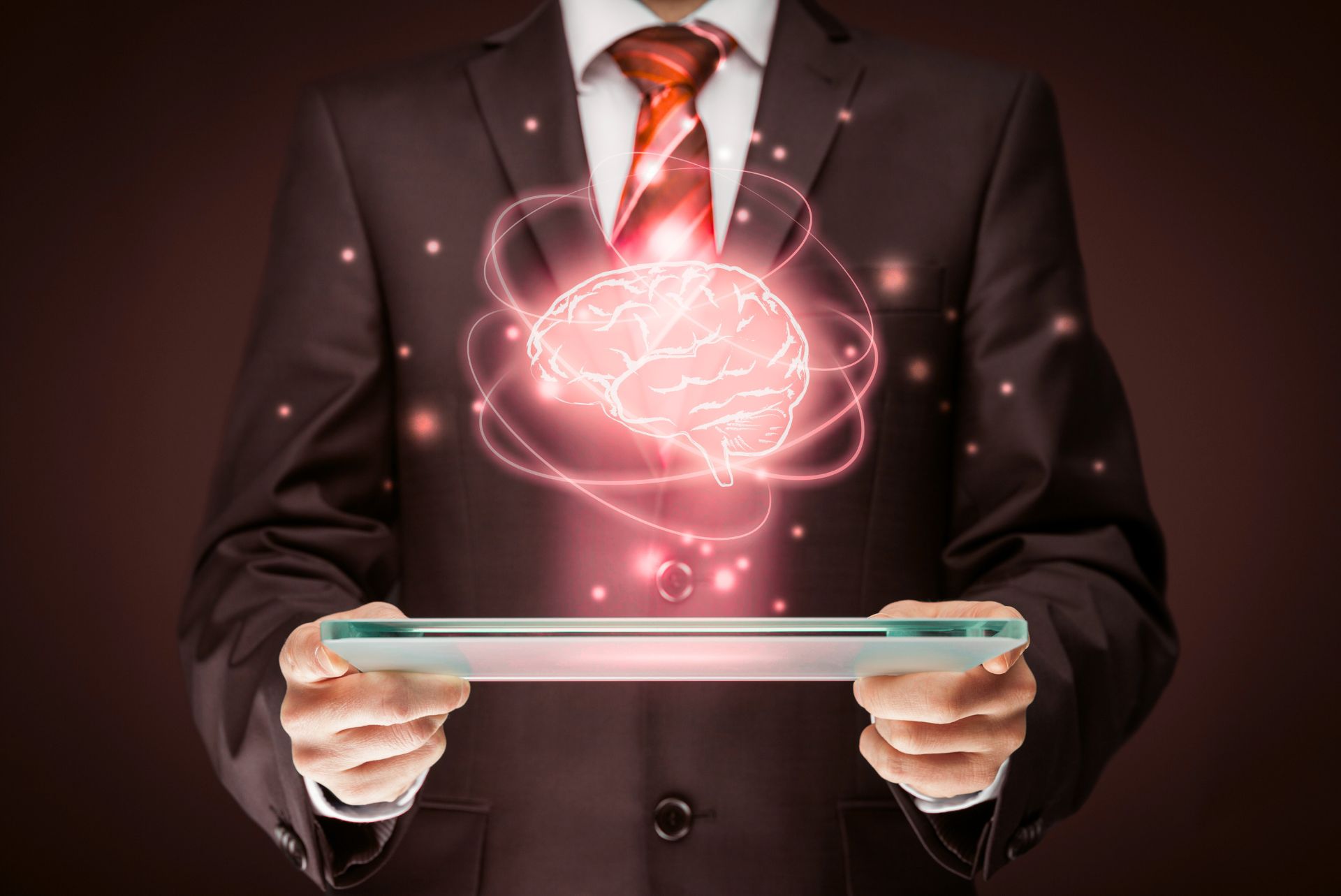 Ejecutivo con tableta mostrando un cerebro digital, símbolo de inteligencia de negocios y análisis avanzado.